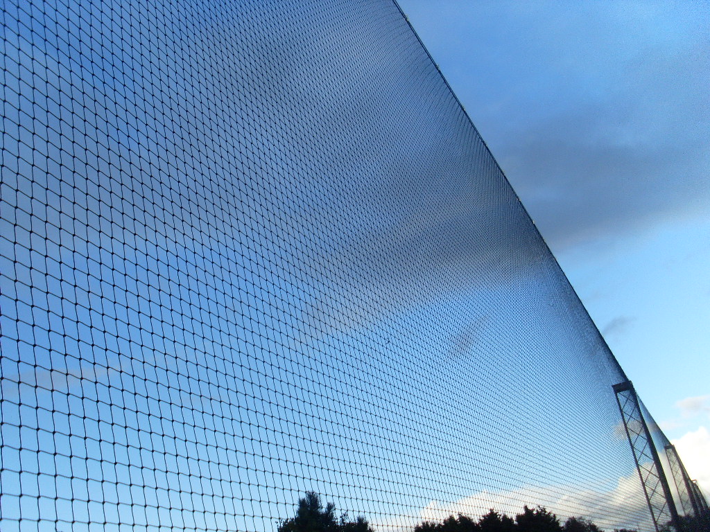 Close-up of golf practice netting against sky background
