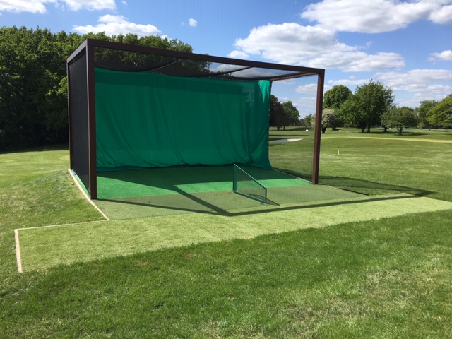 Modern golf practice cage with artificial turf on driving range